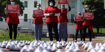 National Nurses United (NNU) display 164 white clogs shoes outside the US Capitol to honor the more than 160 nurses who have lost their lives from COVID-19 in the United States, and to demand the Senate act swiftly to protect nurses on the frontlines in Washington, DC on July 21, 2020. Photo by Olivier DOULIERY / AFP