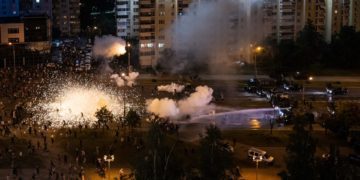 Protesters and riot police clash in Minsk, Belarus during a demonstration against President Lukashenko's claim of a landslide victory. Image credit: Misha Friedman/Getty Images)