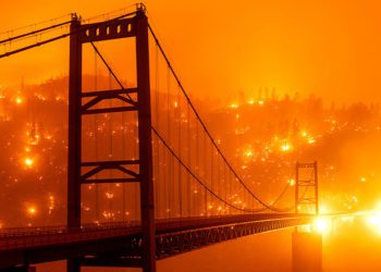 Fire embers light up a hillside behind the Bidwell Bar Bridge. Image credit: AP