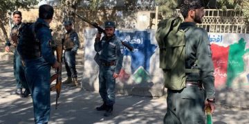 A member of security forces stands guard outside Kabul University after the attack. Image: Reuters