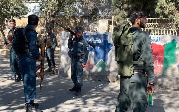 A member of security forces stands guard outside Kabul University after the attack. Image: Reuters