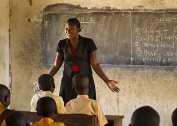 A female teacher teaching science to a classroom of students at a primary school