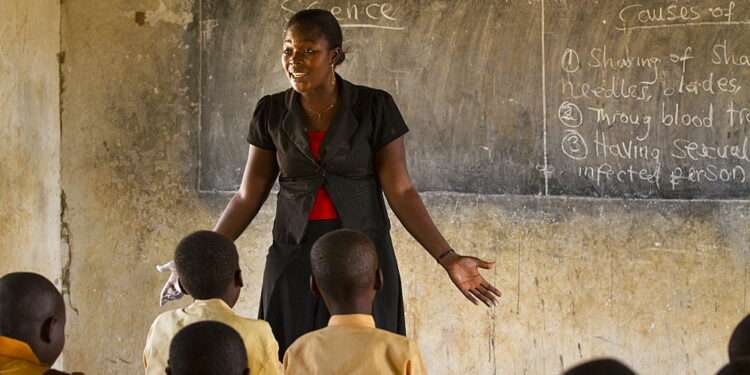 A female teacher teaching science to a classroom of students at a primary school