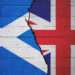 Cracked brick wall painted with a flag of Scotland on the left and a flag of the United Kingdom on the right.