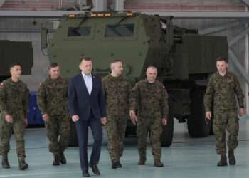 Poland's Defense Minister Mariusz Blaszczak, center, walks during ceremony after receiving its first shipment of U.S.-made HIMARS rocket launchers, at an air base in Warsaw, Poland, on Monday, 15 May 2023.