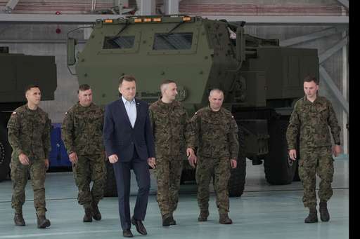 Poland's Defense Minister Mariusz Blaszczak, center, walks during ceremony after receiving its first shipment of U.S.-made HIMARS rocket launchers, at an air base in Warsaw, Poland, on Monday, 15 May 2023.