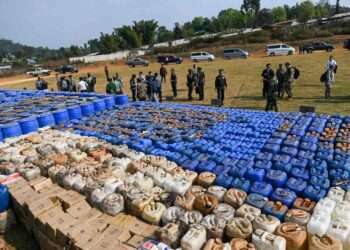 Foreign military attachÈs check drugs in a football ground where seized drugs, vehicles, laboratory accessories and precursor chemicals are being displayed to be witnessed by invited military attachÈs and journalists in Kawnghka at Shan State on March 6, 2020. - 97 million US dollar worth of drugs and related items were seized this year during a special operation held to crack down drugs trafficking, a military spokesperson said. (Photo by YE AUNG THU / AFP)