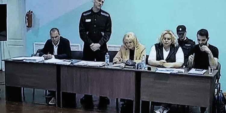 A view of a TV Screen showing Russian opposition leader, Alexei Navalny, 2nd left, between his lawyers in a courtroom, during a preliminary hearing, in Melekhovo on Monday, June 19, 2023.