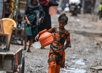 A Rohingya girl walks through a refugee camp in Delhi.