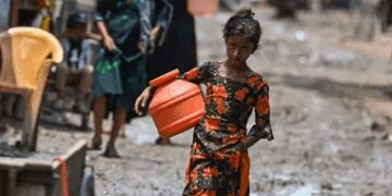 A Rohingya girl walks through a refugee camp in Delhi.