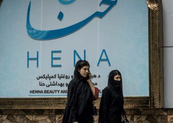 Women walk past a beauty salon in the Shahr-e-Naw area of Kabul ahead ahead of the order for beauty parlours across the country to shut permanently.