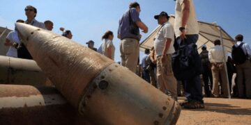 Activists and international delegations stand next to cluster bomb units, during a visit to a Lebanese military base at the opening of the Second Meeting of States Parties to the Convention on Cluster Munitions, in the southern town of Nabatiyeh, Lebanon, Sept. 12, 2011.