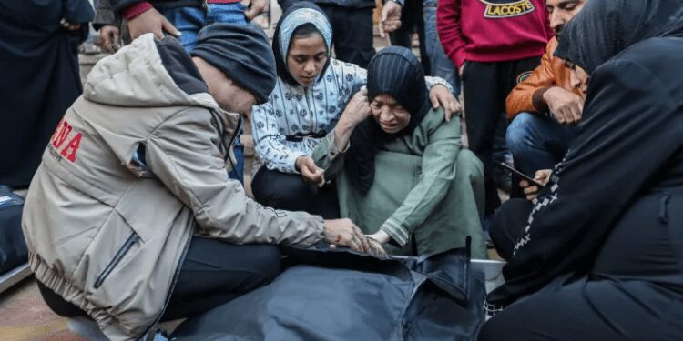 People mourn as they collect the bodies of Palestinians killed in an air strike in Khan Younis, Gaza.