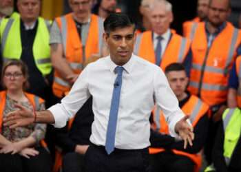 British Prime Minister Rishi Sunak speaks with staff at a transport distribution center in Ilkeston, Britain