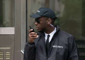 Young African Male Security Guard Talking On Walkie-Talkie