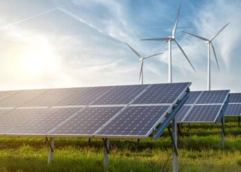 solar panels and wind generators under blue sky on sunset