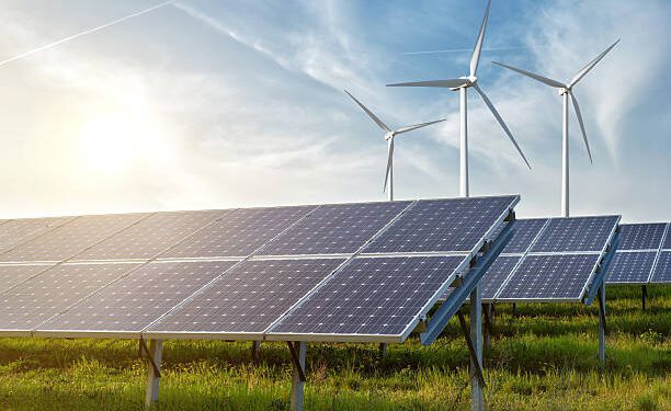 solar panels and wind generators under blue sky on sunset