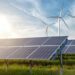solar panels and wind generators under blue sky on sunset