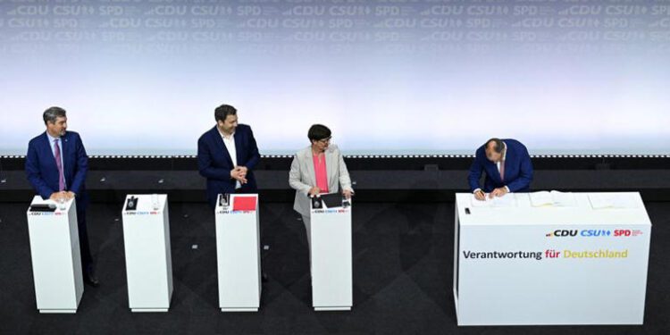 Incoming German Chancellor and leader of the Christian Democratic Union (CDU) Friedrich Merz signs the coalition government agreement between CDU, CSU and SPD, as Christian Social Union (CSU) leader and Bavarian Premier Markus Soeder, Designated German Vice Chancellor and Designated Finance Minister Lars Klingbeil and Social Democratic Party of Germany (SPD) co-leader Saskia Esken look on, at the Gasometer in Berlin, Germany May 5, 2025.