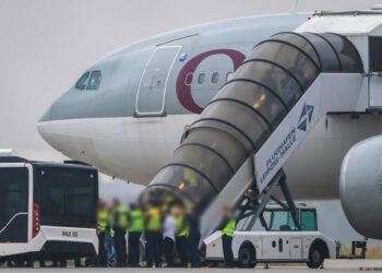 People board a Qatar Airways plane.