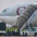 People board a Qatar Airways plane.