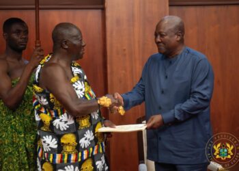 Asantehene Otumfuo Osei Tutu II (L) handing over the Mediation Report to President John Dramani Mahama (R)