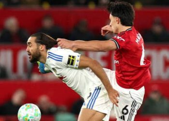 Calvert-Lewin (White) and Lisandro Martinez (red) battle for the ball