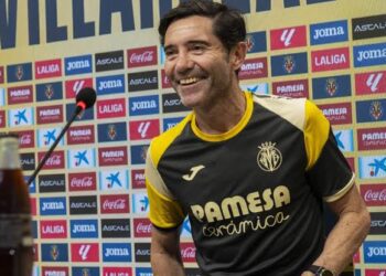 Marcelino smiling as he takes his seat at a pre-match presser