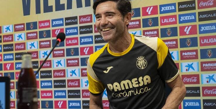 Marcelino smiling as he takes his seat at a pre-match presser