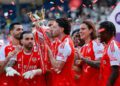 Declan Rice kisses the Premier League trophy while celebrating with his Arsenal teammates at Selhurt Park
