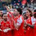 Declan Rice kisses the Premier League trophy while celebrating with his Arsenal teammates at Selhurt Park