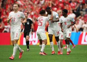 Canada players celebrating after making knockout round of the FIFA World Cup for the first time in their history