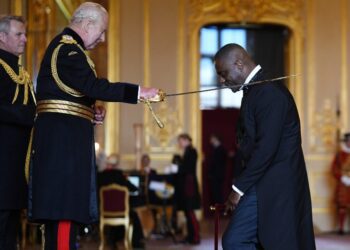 King Charles III knighting Idris Elba