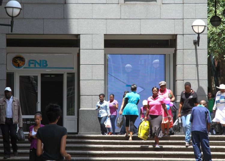 Banking: FirstRand to Build One-Stop Banking Shop in Ghana 1 Pedestrians pass the headquarters of First National Bank (FNB), a division of FirstRand Bank Ltd., in Johannesburg.