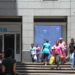 Pedestrians pass the headquarters of First National Bank (FNB), a division of FirstRand Bank Ltd., in Johannesburg.