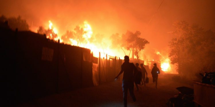 Fire destroys Greek camp leaving 13,000 without shelter 1 Refugees and migrants run as fire burns in the Moria refugee camp on the northeastern Aegean island of Lesbos, Greece. Image credit: AP