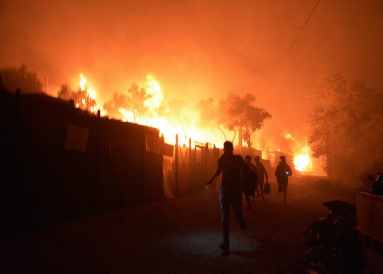 Refugees and migrants run as fire burns in the Moria refugee camp on the northeastern Aegean island of Lesbos, Greece. Image credit: AP
