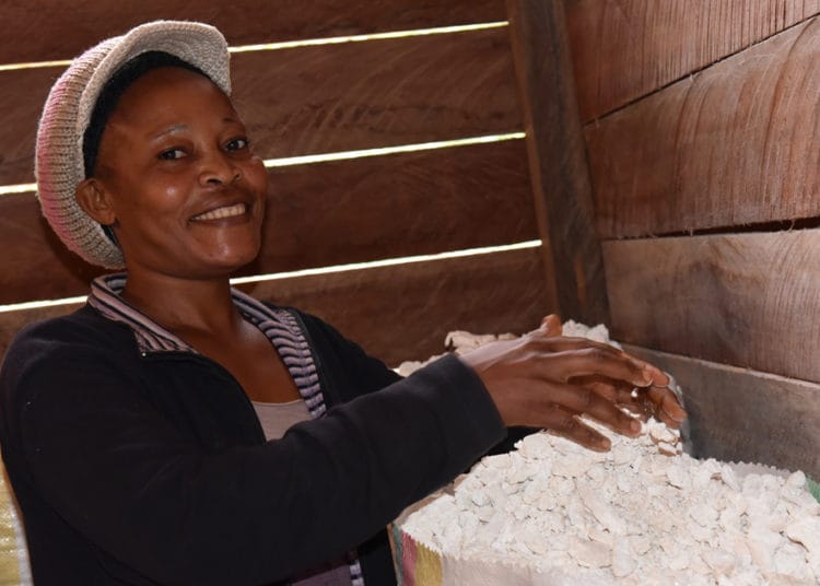 A member of the Zoulaboot Community Forest filling dried cassava into 100 kg bags for sale