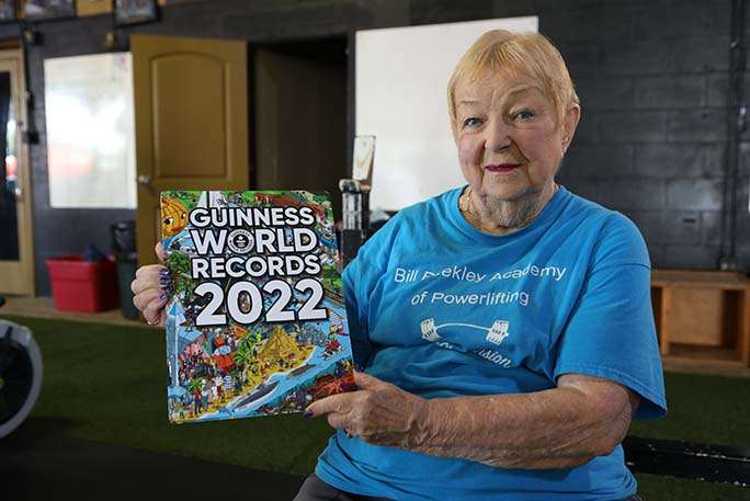Oldest competitve powerlifter edith murway traina poses with 2022 Guinness World Records book tcm25 670270