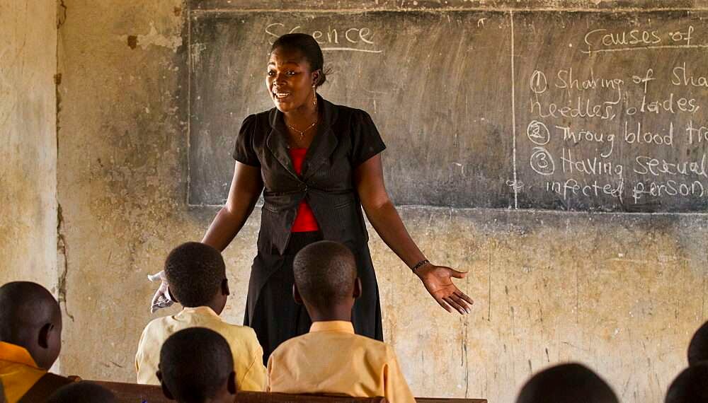 A female teacher teaching science to a classroom of students at a primary school