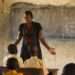 A female teacher teaching science to a classroom of students at a primary school