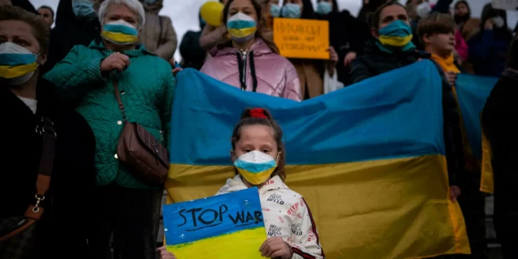 Ukrainians and supporters hold placards and a Ukraine national flag during a demonstration against the Russian invasion of the Ukraine in front of the Greek Parliament in Athens, on March 1, 2022 Angelos Tzortzinis AFP