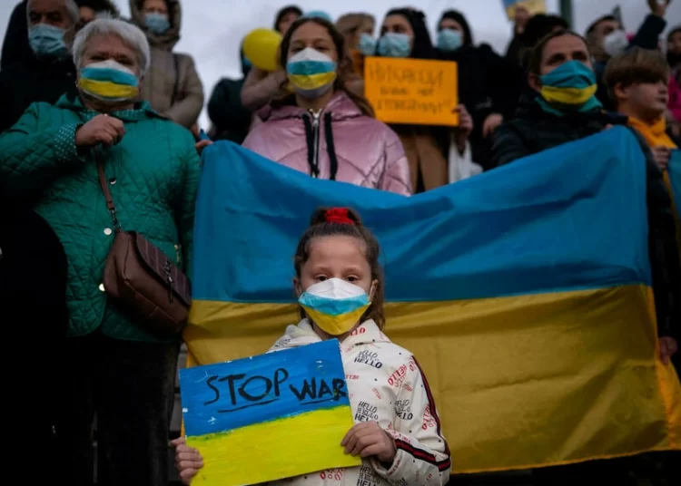 UN General Assembly to Vote to Demand Russia Withdrawal From Ukraine 1 Ukrainians and supporters hold placards and a Ukraine national flag during a demonstration against the Russian invasion of the Ukraine in front of the Greek Parliament in Athens, on March 1, 2022 Angelos Tzortzinis AFP