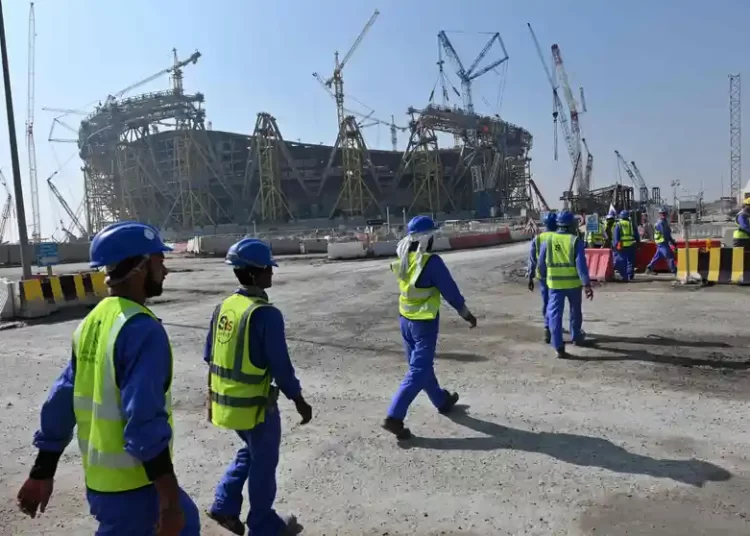 Construction workers heading towards a world cup stadium site.