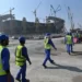 Construction workers heading towards a world cup stadium site.