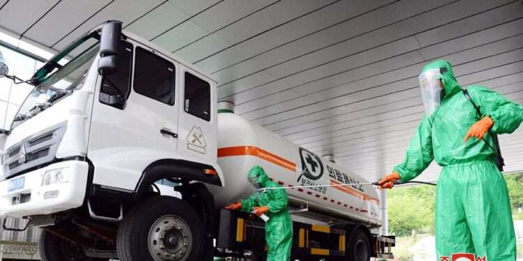 A worker disinfects a vehicle carrying medical oxygen, in Pyongyang