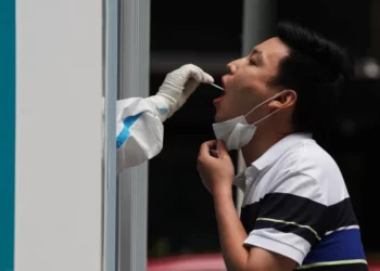 A medical worker takes a swab sample from a person at a mobile nucleic acid testing booth, following the coronavirus outbreak in Beijing [Tingshu WangReuters]