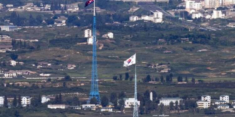 Flags of North Korea, rear, and South Korea, front, flutter in the wind as pictured from the border area between two Koreas in Paju, South Korea, on Aug. 9, 2021.