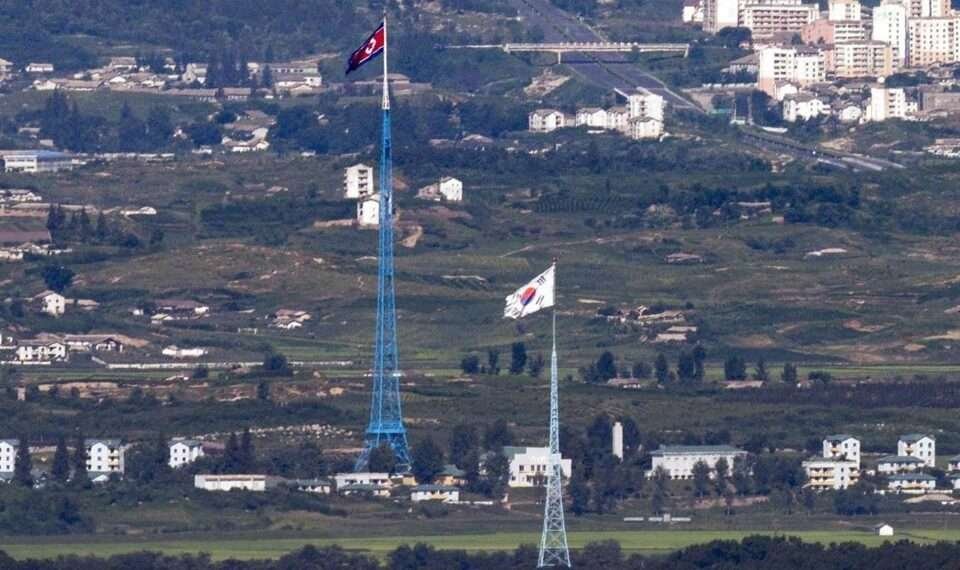 Flags of North Korea, rear, and South Korea, front, flutter in the wind as pictured from the border area between two Koreas in Paju, South Korea, on Aug. 9, 2021.