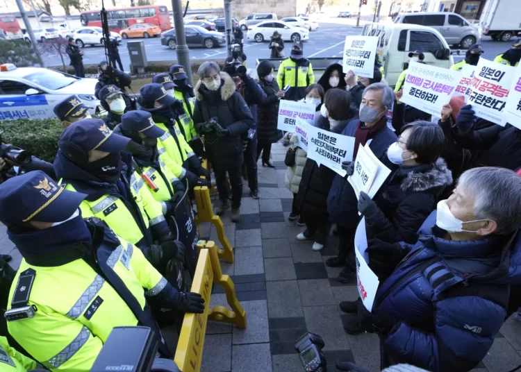 Protesters confront police officers during a rally to oppose Japan's adoption of a new national security strategy near the Japanese Embassy in Seoul, South Korea, Tuesday, Dec. 20, 2022.